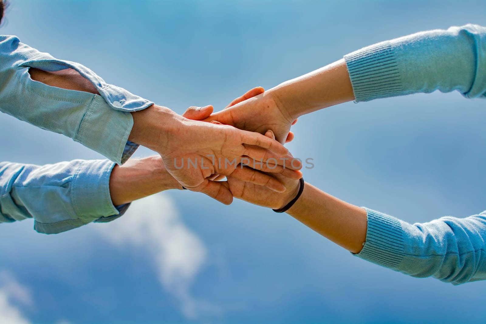 Concept of one hand over another forming a team, Concept of unity with the hands, palms together all for one and one for all, hands crossed in a concept of union.