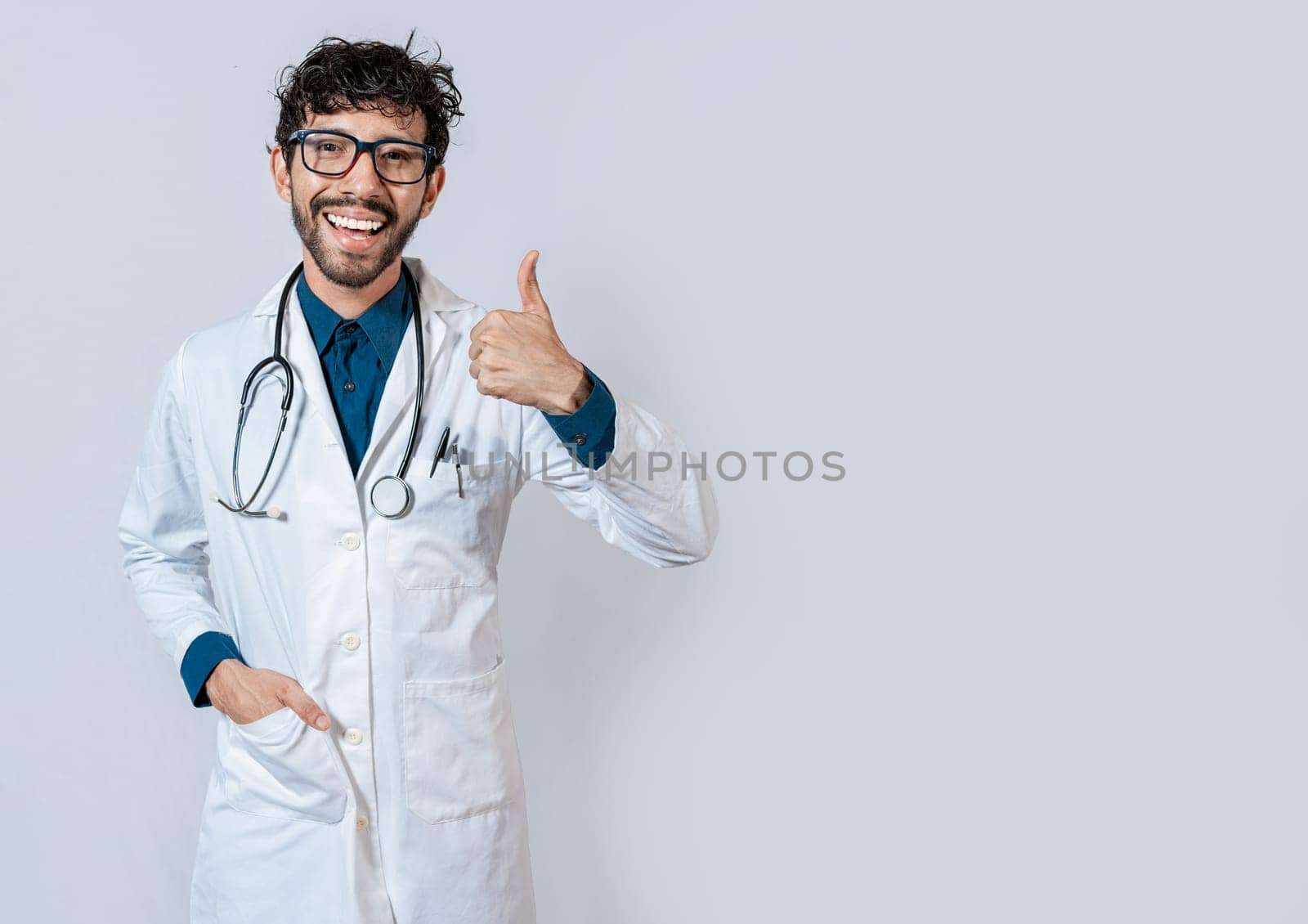 Smiling doctor giving thumb up isolated. Handsome doctor with thumb up smiling isolated. Young doctor with thumbs up gesture