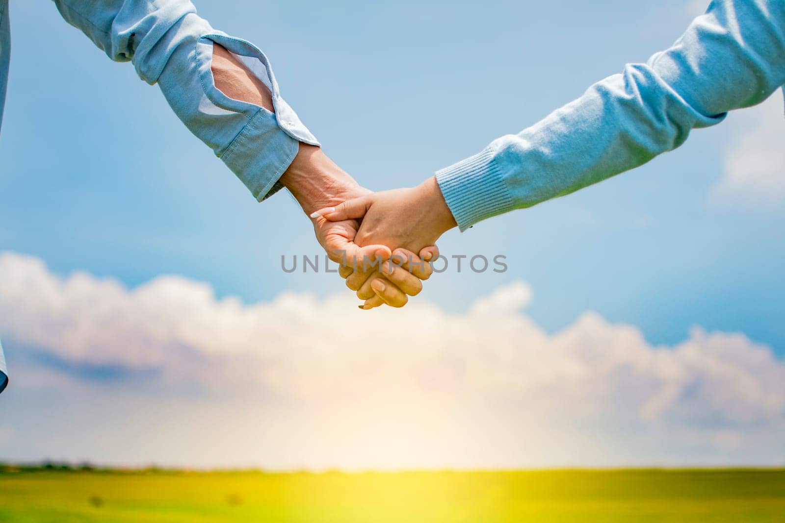 Close up of a couple holding hands, Concept of couple hands holding hands, Hands together of a couple in the field