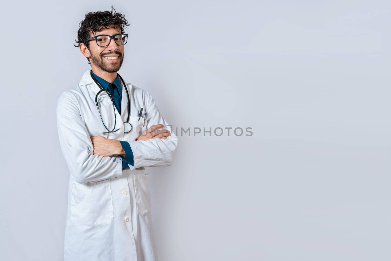 Smiling doctor with crossed arms on isolated background. Latin doctor with crossed arms on isolated background, Portrait of young doctor with arms crossed