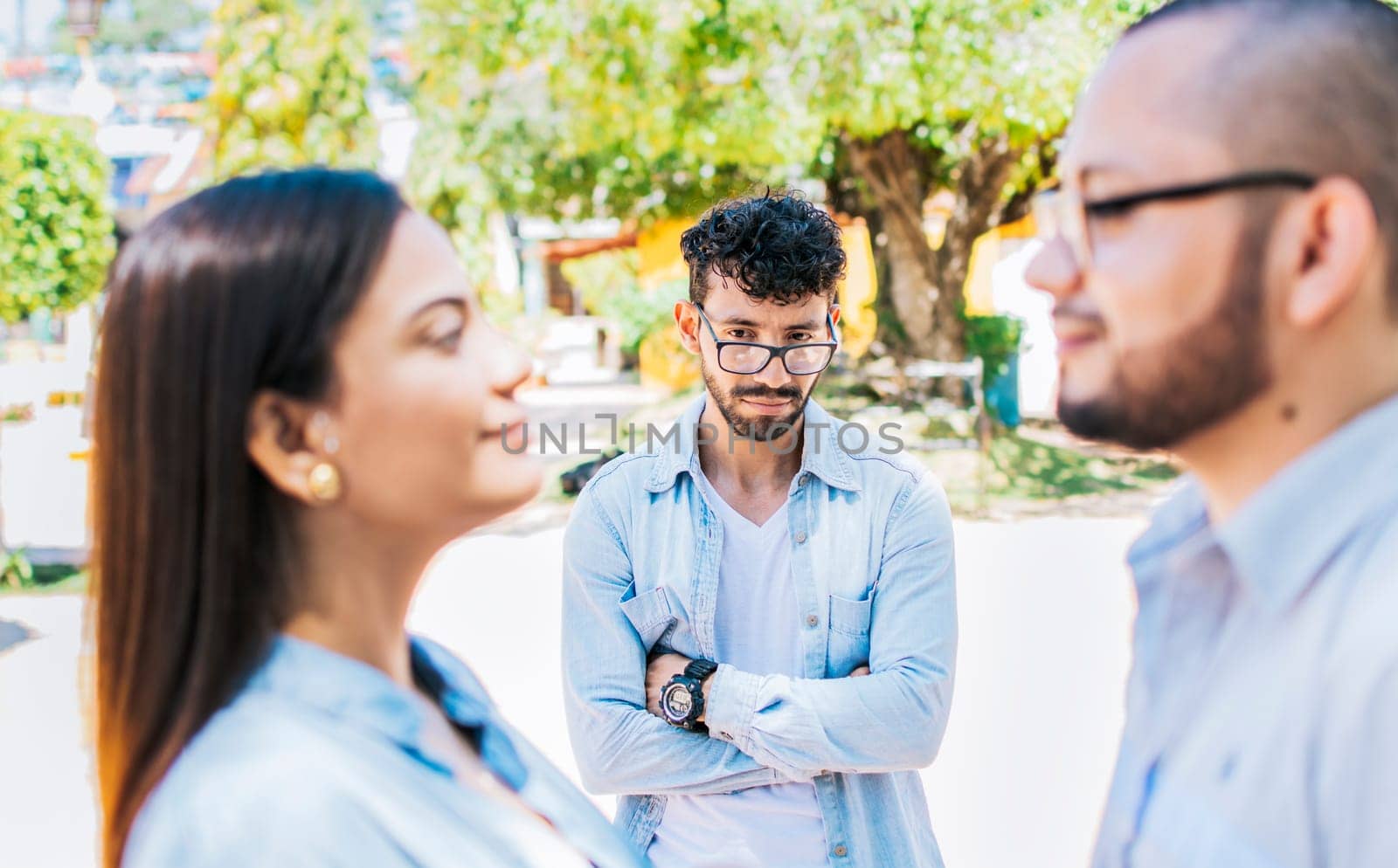 Sad man seeing his girlfriend cheating with his friend outdoors, Sad boyfriend seeing his girlfriend with another one outdoors. Man watching his girlfriend cheating with another man