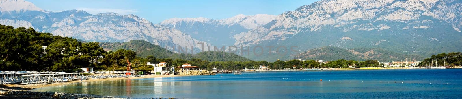 Kemer Antalia nice view of the sea. Beach Kemer Antalia with sand and mountains, the sea with the ship. Beautiful harbor near the sandy beach.