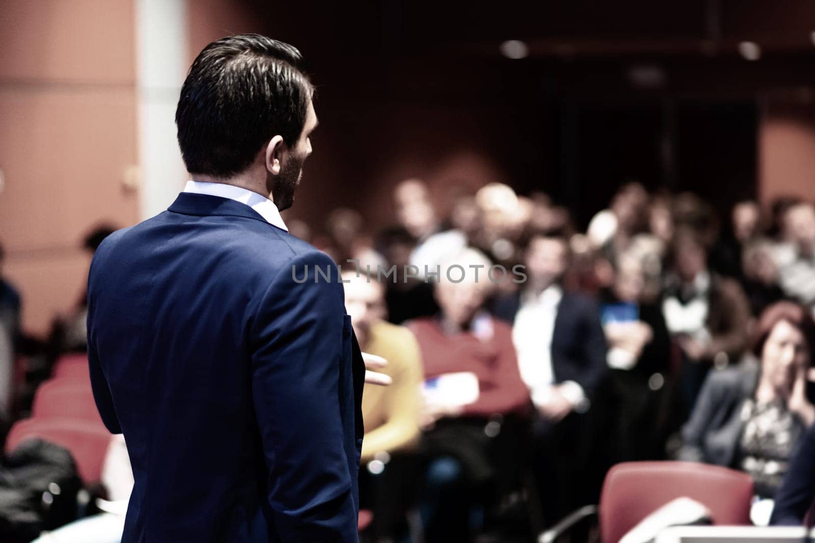 Speaker giving a talk on corporate Business Conference. Audience at the conference hall. Business and Entrepreneurship event.