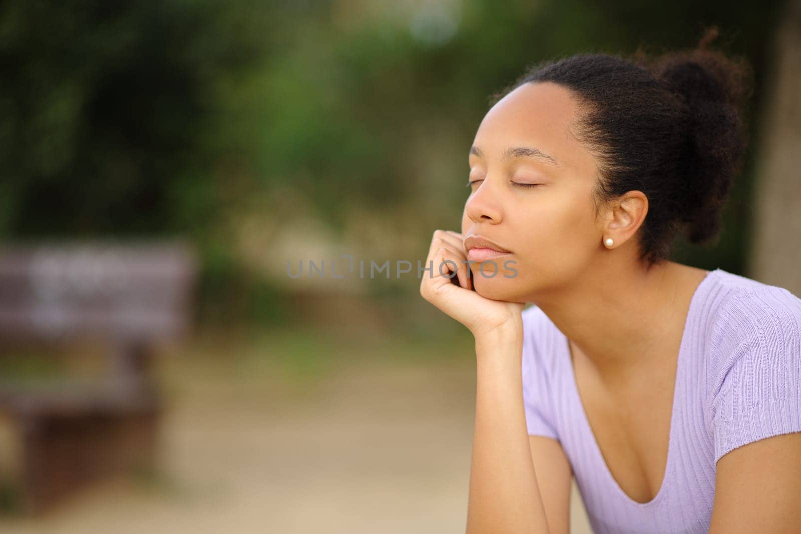 Black woman relaxing mind sitting alone in a park