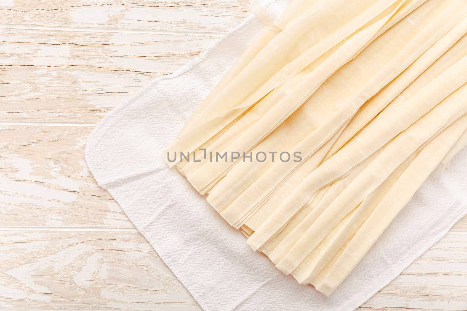 Raw phyllo pastry, thin filo dough for baking, for pie and cakes on wooden kitchen table