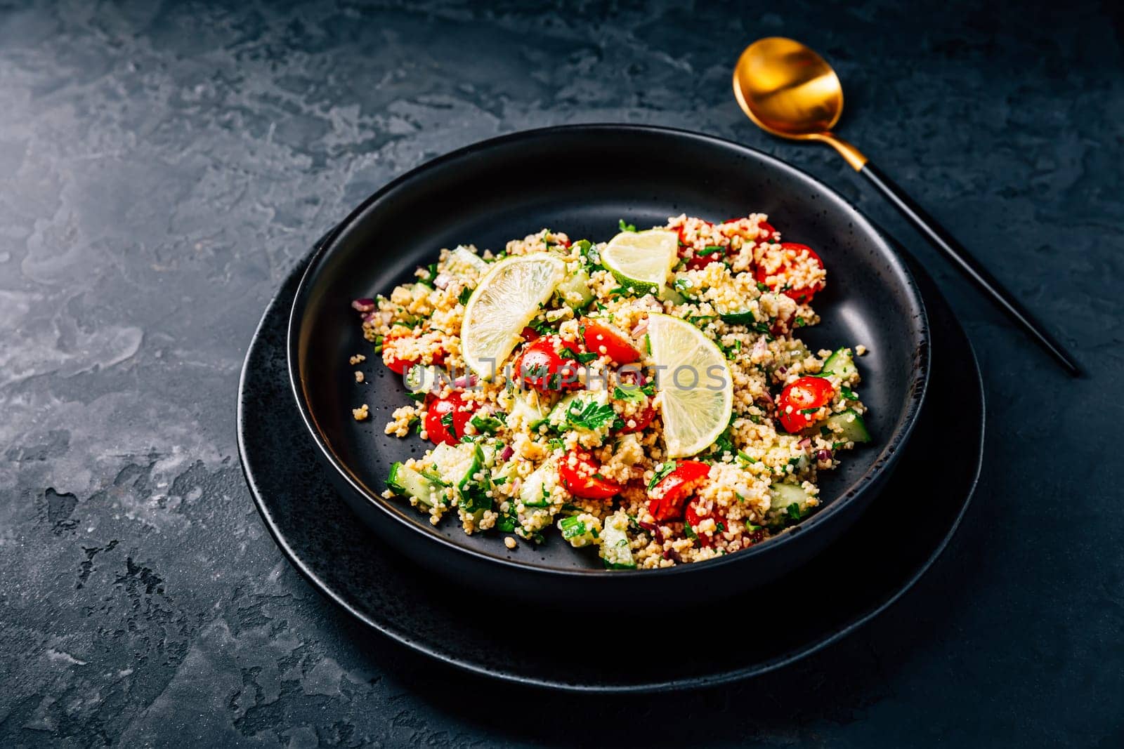 Tabbouleh salad, traditional middle eastern and arab dish. Levantine vegetarian salad with parsley, mint, bulgur, tomato and cucumber