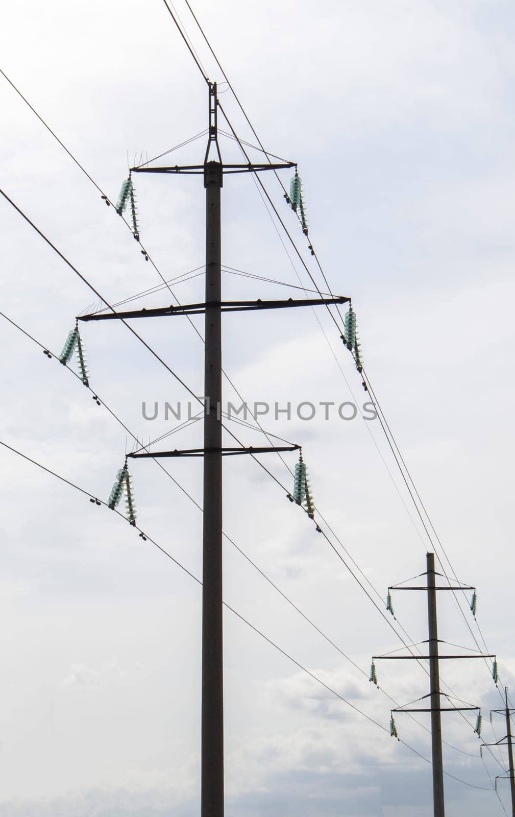 High voltage electrical tower against the sky. High voltage power lines. Electrical distribution station. The passage of the overhead line wire supports carrying light and heat into the house