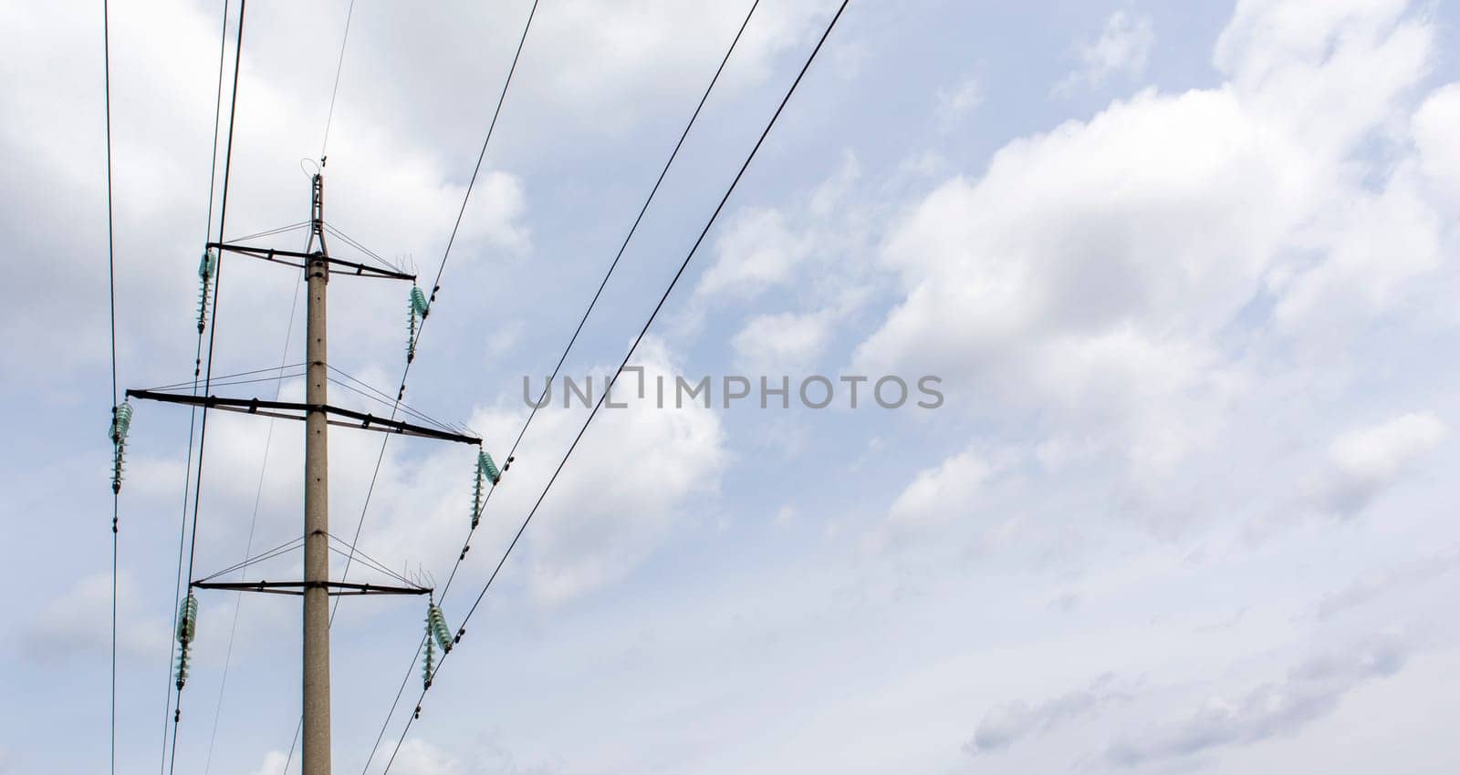 High voltage electrical tower against the sky. High voltage power lines. Electrical distribution station. The passage of the overhead line wire supports carrying light and heat into the house