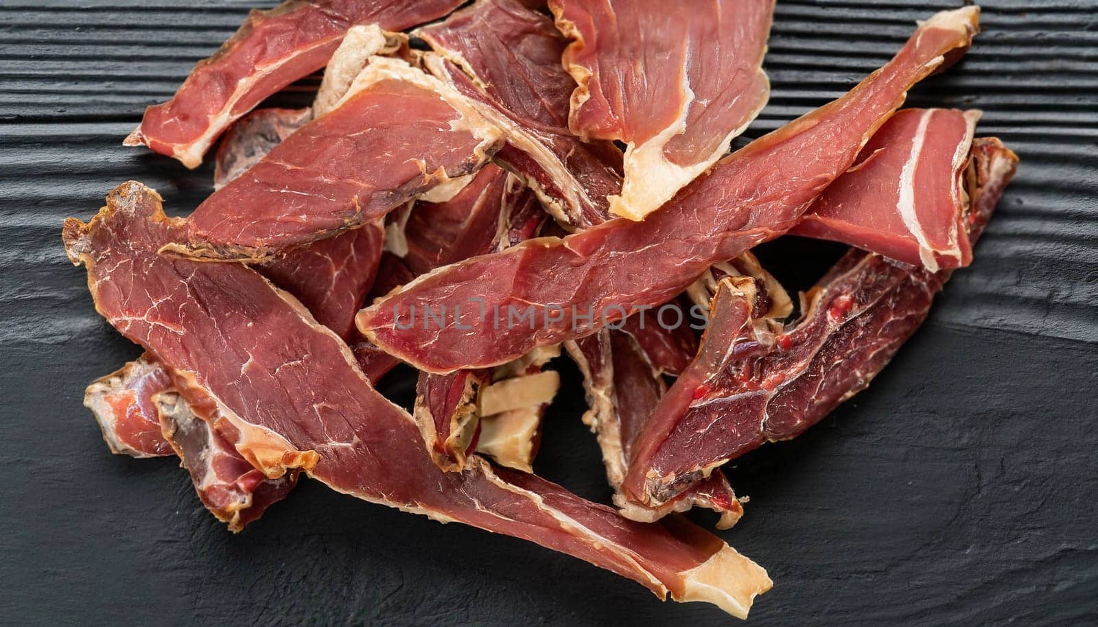 Raw pork sliced meat on wooden board on white background with dry basil leaves and spice. fresh raw beef lamb isolated on white. Heap of raw steaks