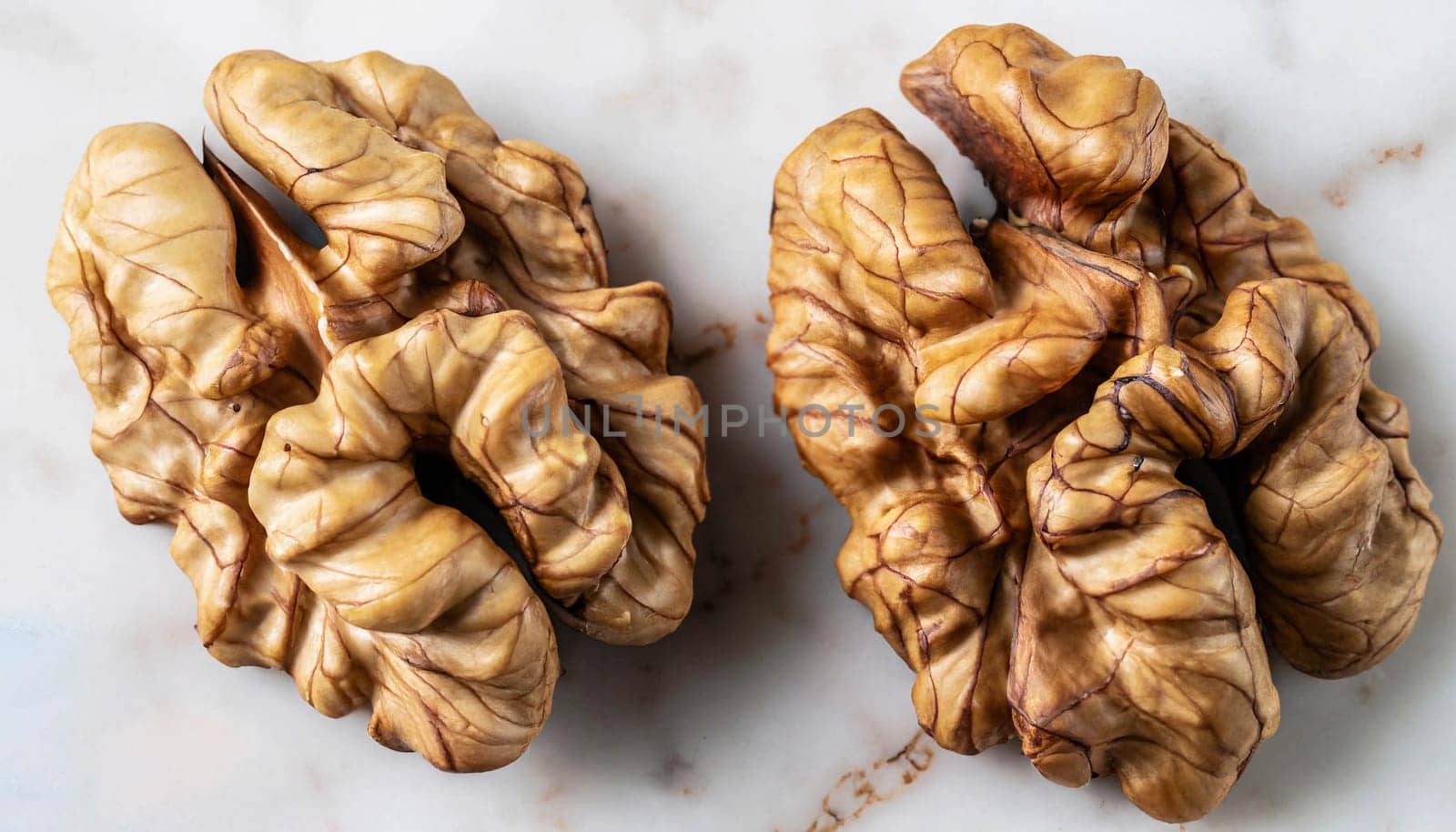 Full frame top view of heap of fresh raw brown crispy walnuts arranged on surface