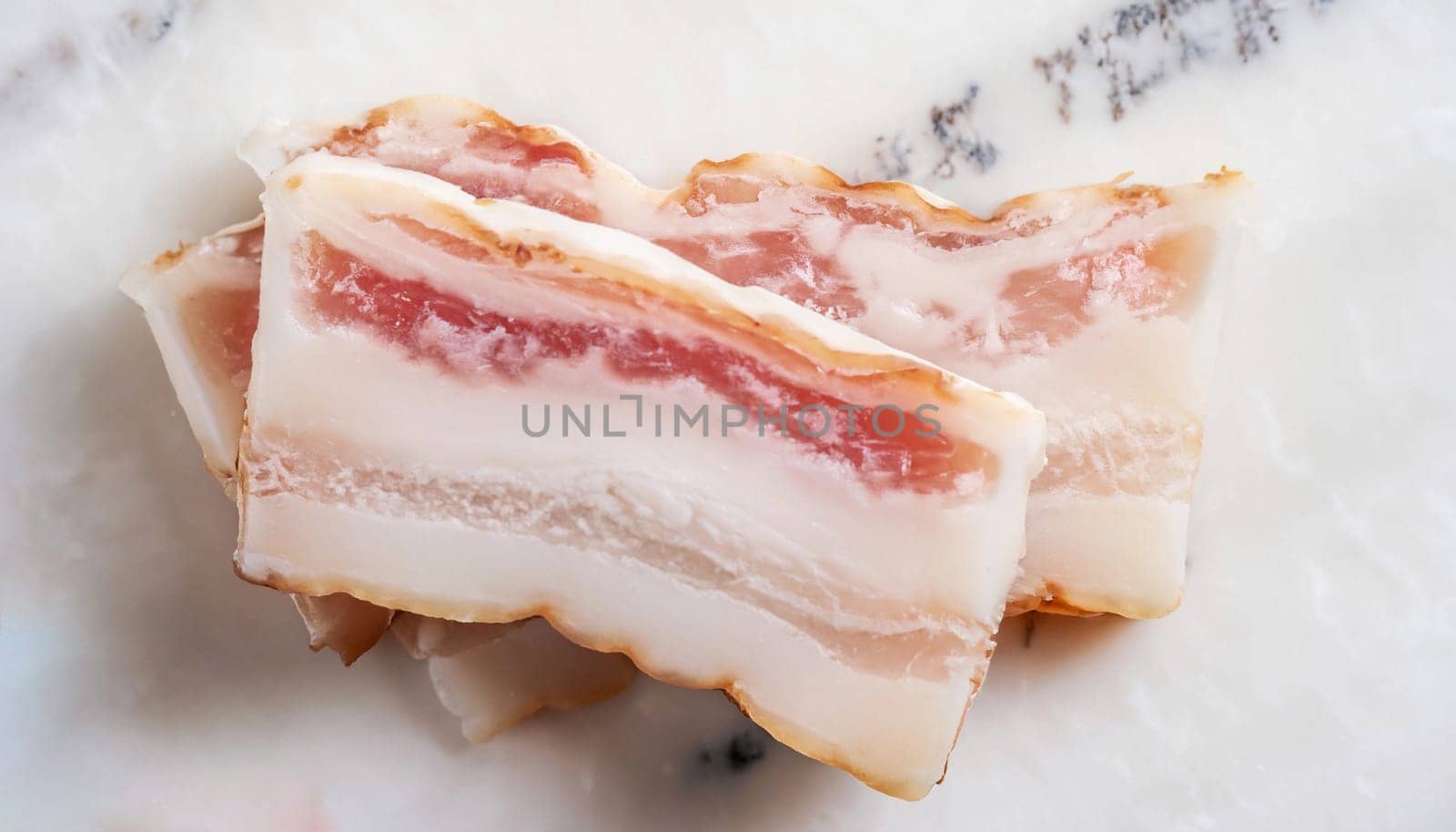 Pile of salted pork lard on white marble table