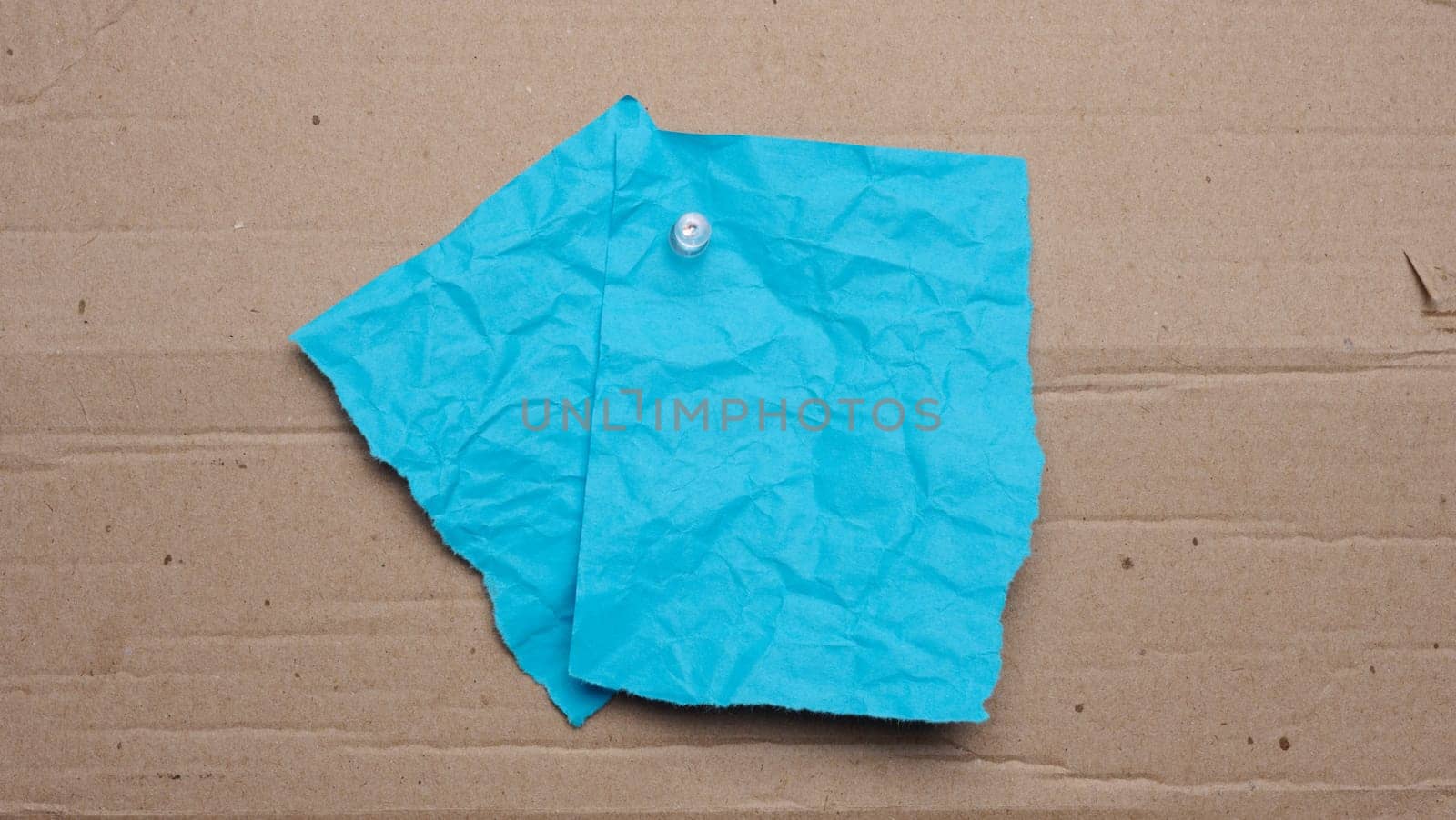 Blue sheet with tear-off edges for writing an ad on a brown background, copy space