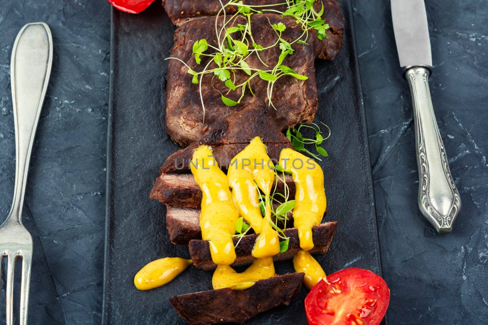 Roasted ostrich meat steaks with sauce. African cuisine. Copy space