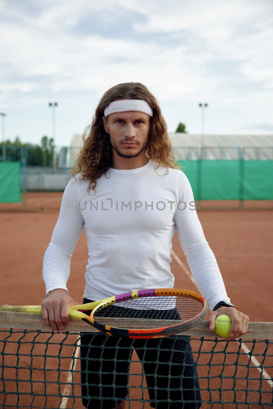 Portrait of serious male tennis player feeling strong and motivation. Young athletic sportsman looking determined and confident