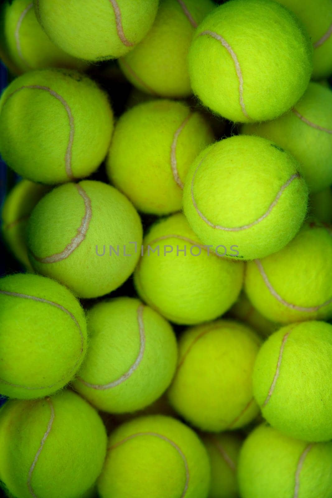 Lots of vibrant green tennis ball pattern background. Full frame sports equipment for training, tournament and competition match. Hobby and recreational activity, shop store advertisement