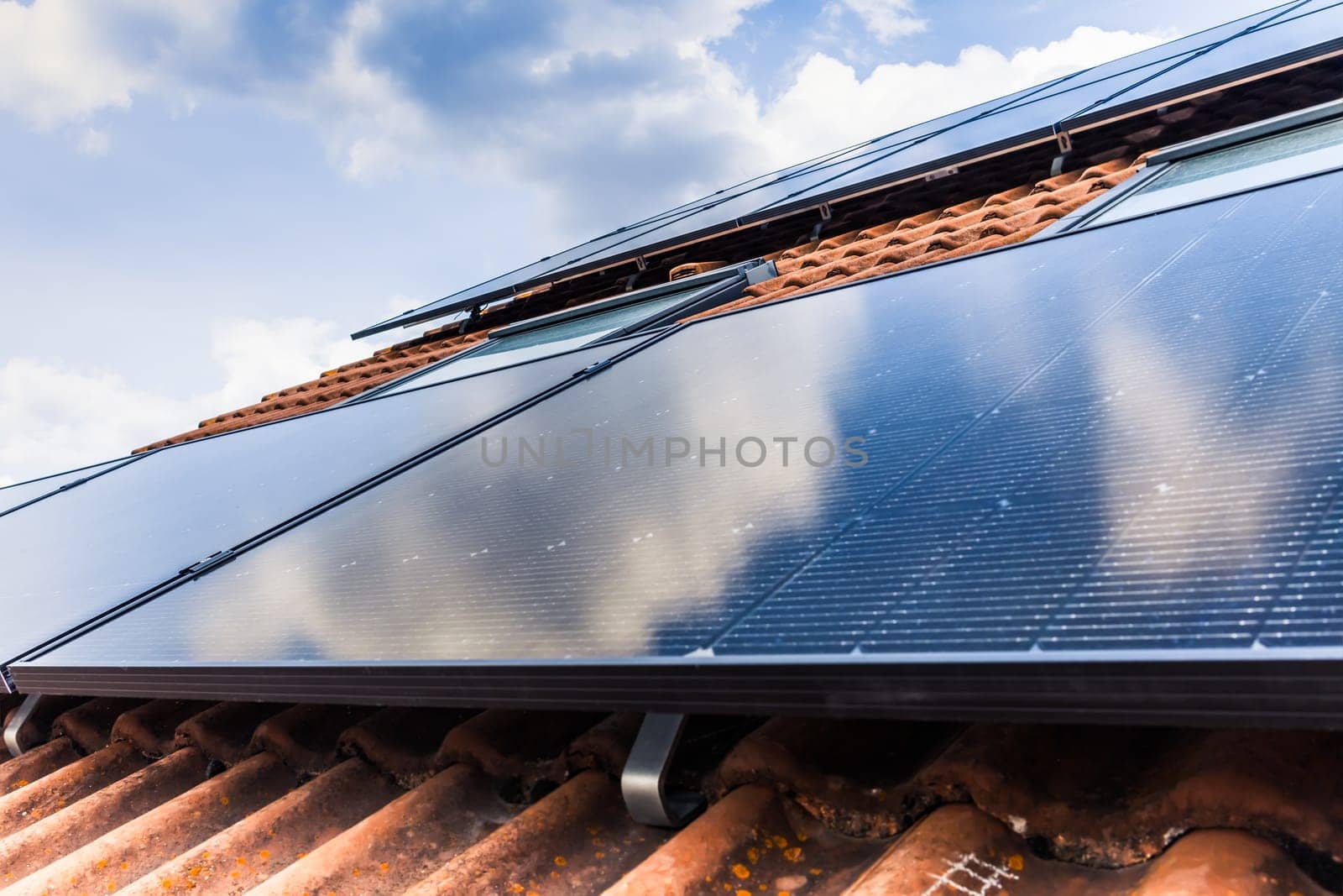 Photovoltaic panels on the roof of family house, solar panels. Environment and technology concepts.