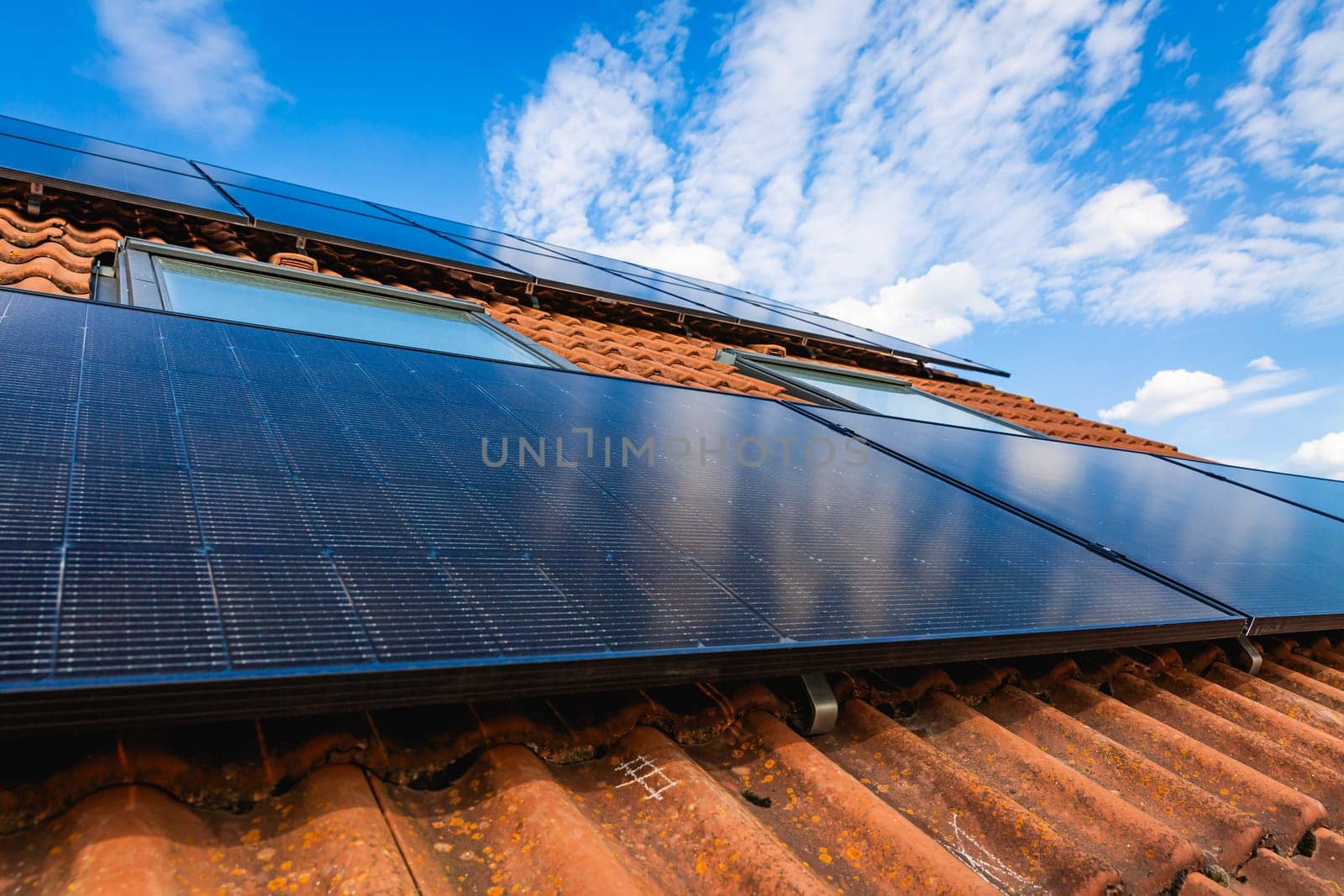 Photovoltaic panels on the roof of family house, solar panels. Environment and technology concepts.