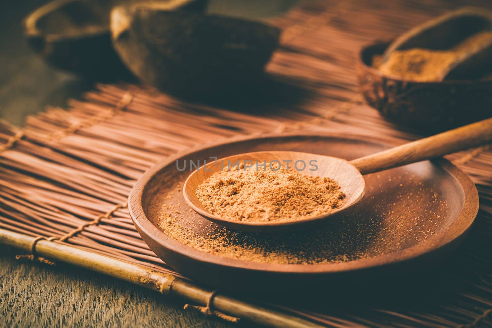 Organic coconut plam sugar in wooden scoop and bowl