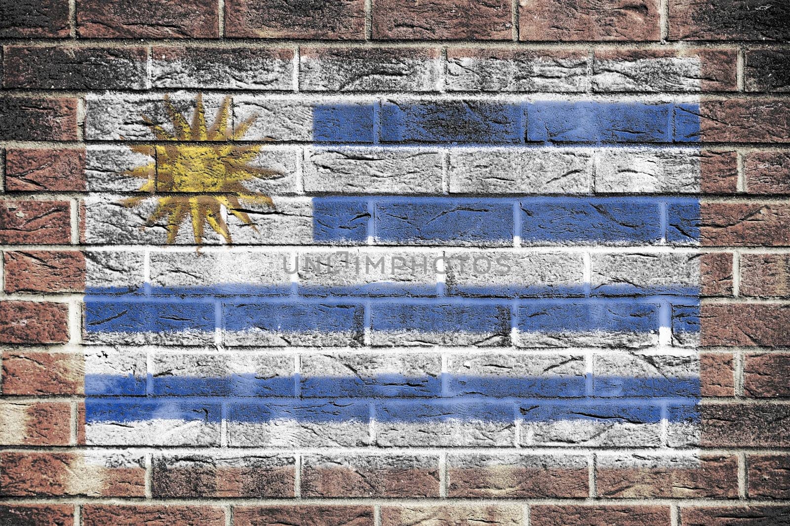 A Uruguay flag on a brick wall background blue white stripes Sun of May