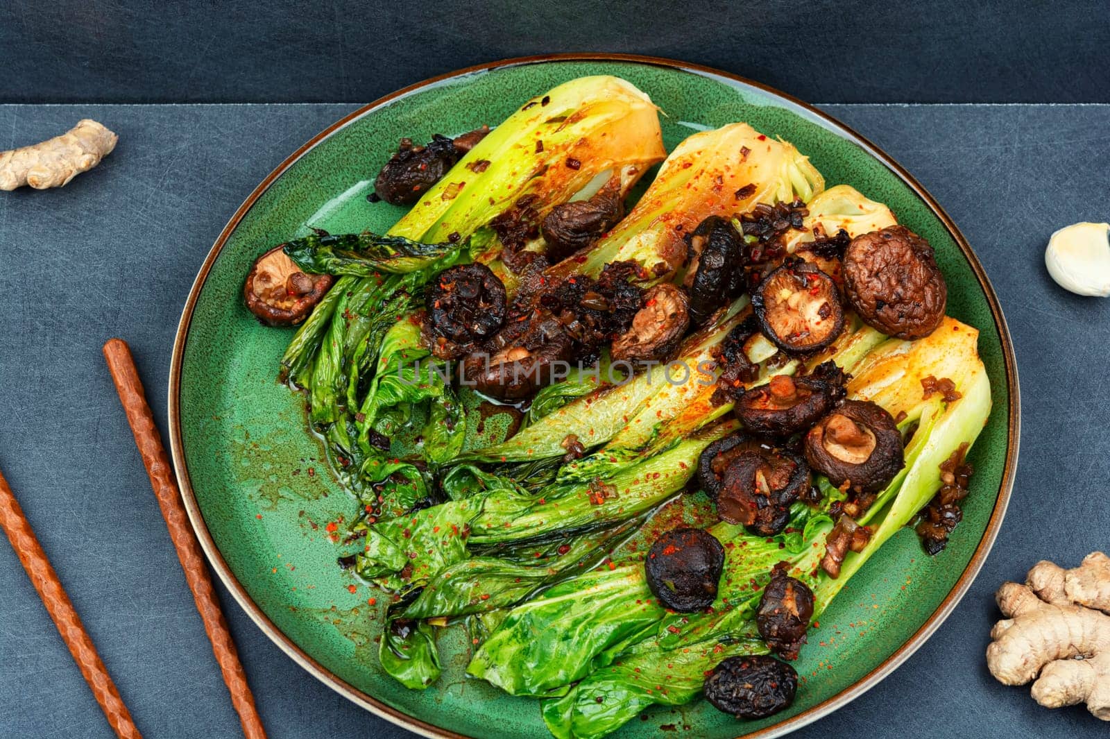 Chinese fried Pak Choi with shitake mushrooms and chopstick. Asian vegan food