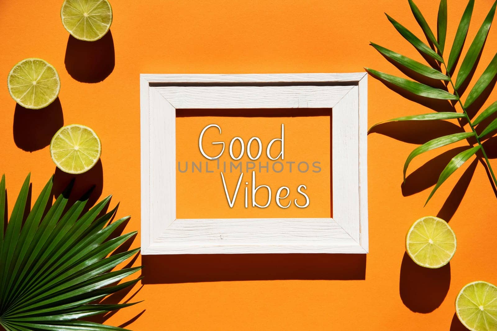 Flat Lay With English Text Good Vibes. Orange Background With Picture Frame And Tropical Lemon And Palm Leaf.