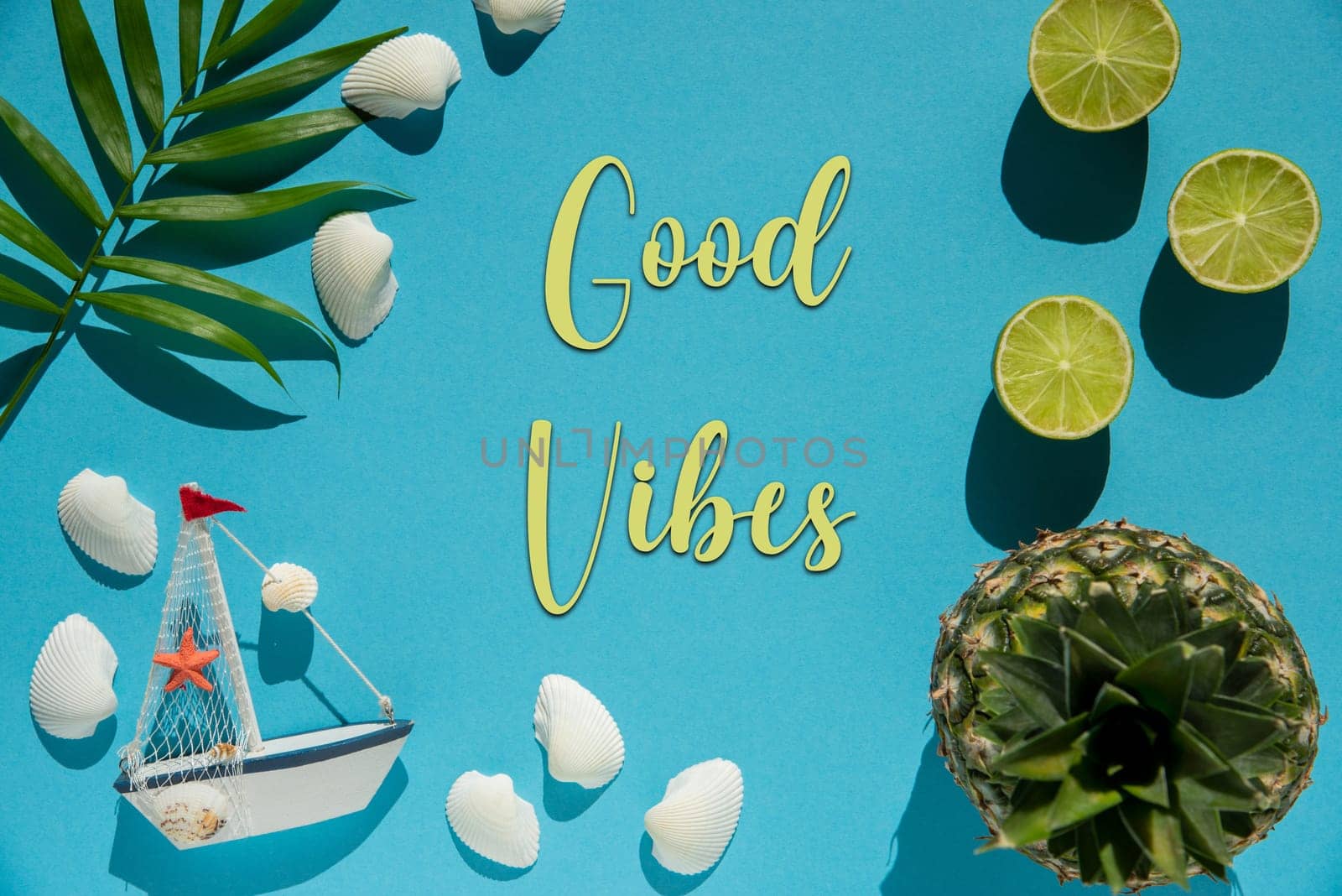 Flat Lay With English Text Good Vibes. Turquoise Or Blue Background Wit Decoration Like Pineapple, Shells, Boat And Lemons.