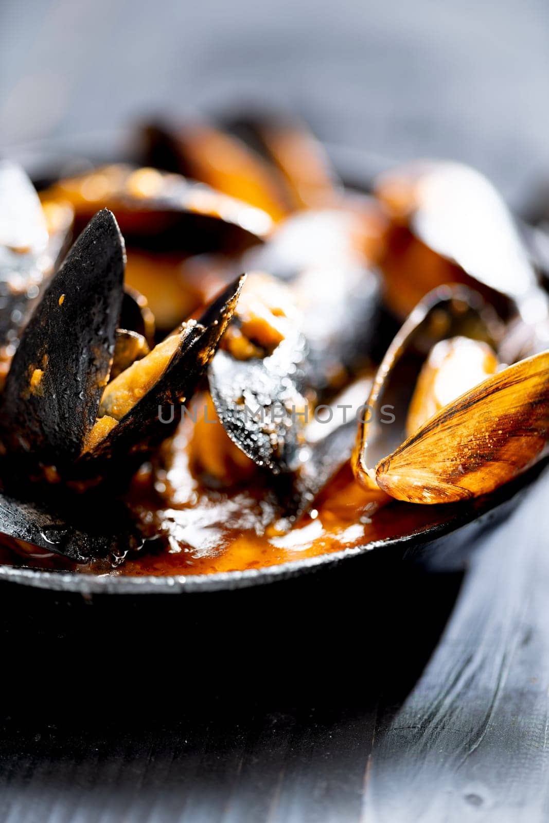 close up of a pan of italian black mussels in tomato sauce