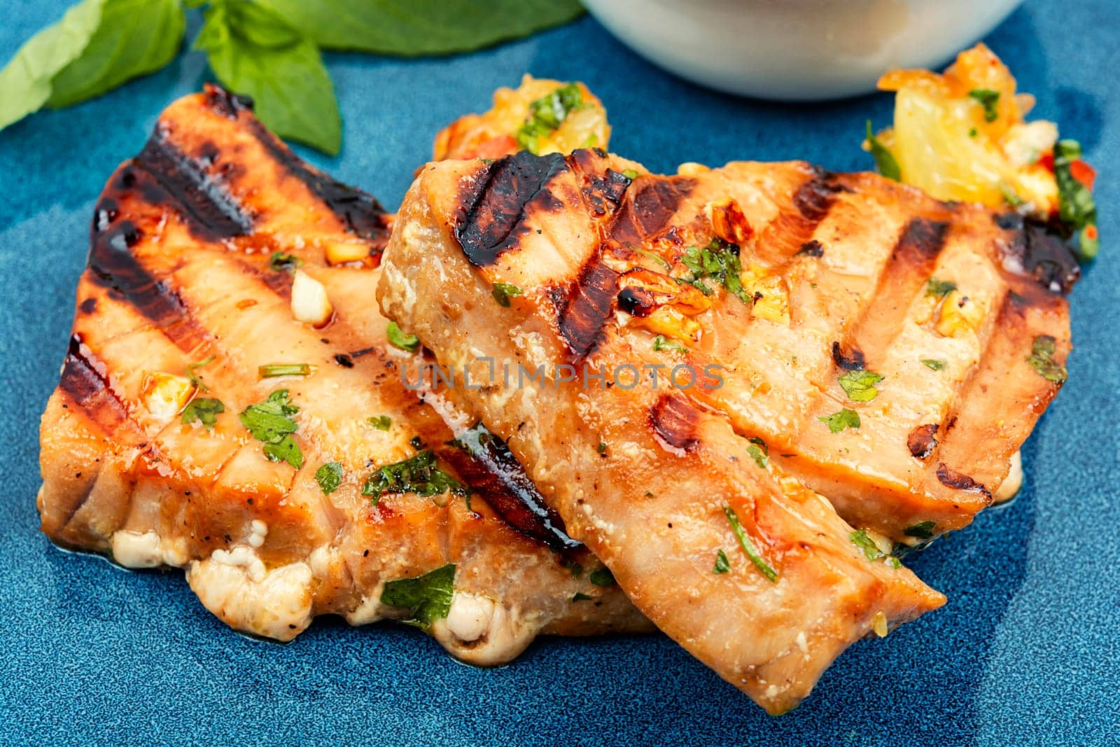Grilled tuna steak with sauce on a plate. Seafood fried. Close up.