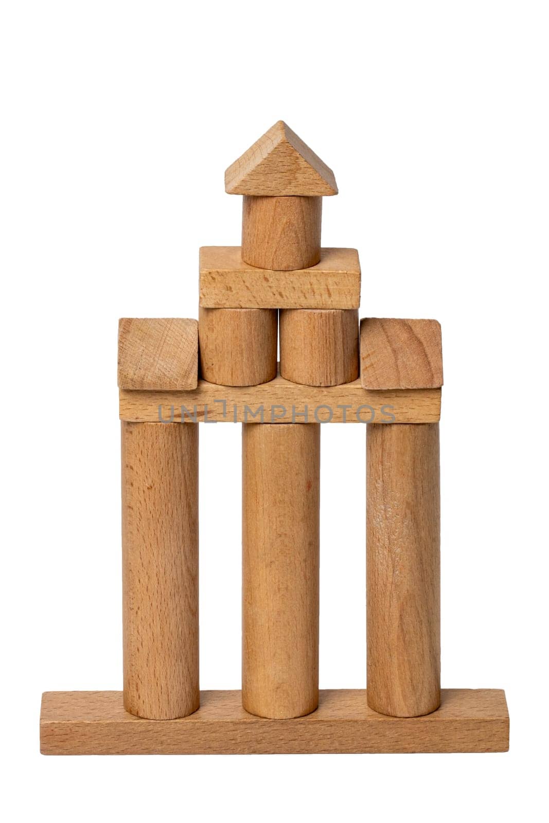 Wooden isolated house. Wooden toy castle constructed of cubes, cylinders, triangles and other shapes made of beech wood. Wooden toy blocks. Macro.