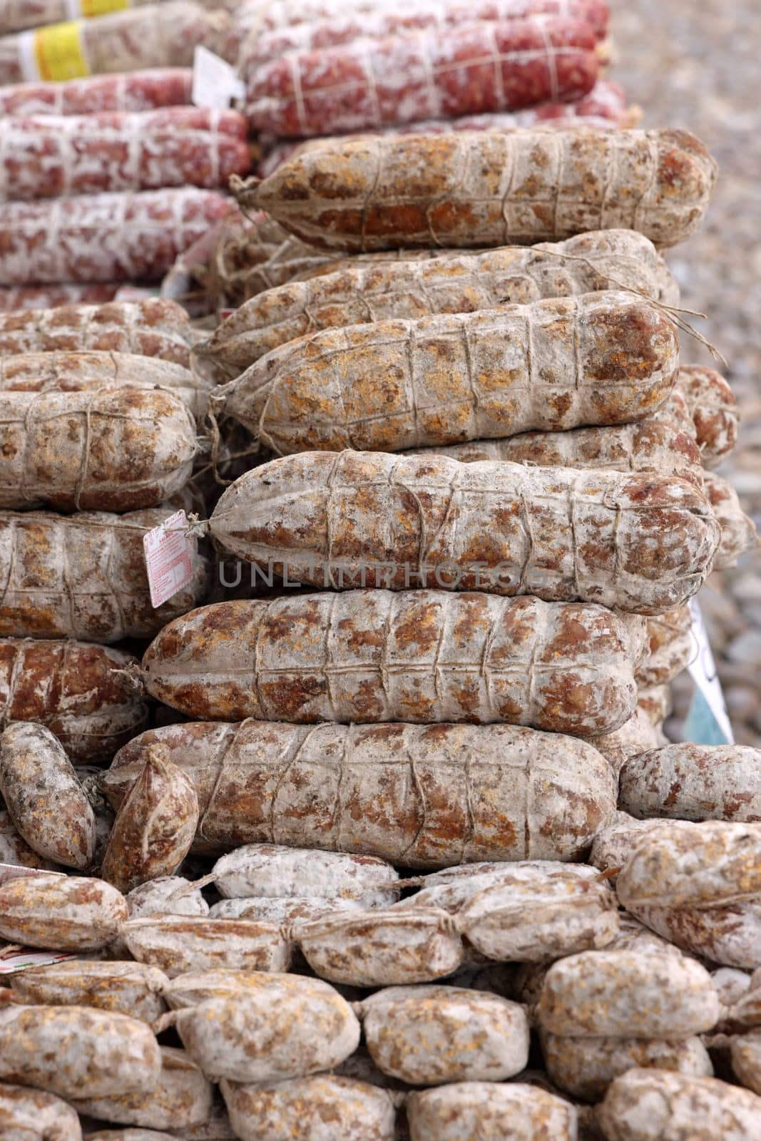 Cremona, Italy - September 7, 2022: Traditional meat products sold at a street stall during the farmers market in Cremona, Lombardy, Italy