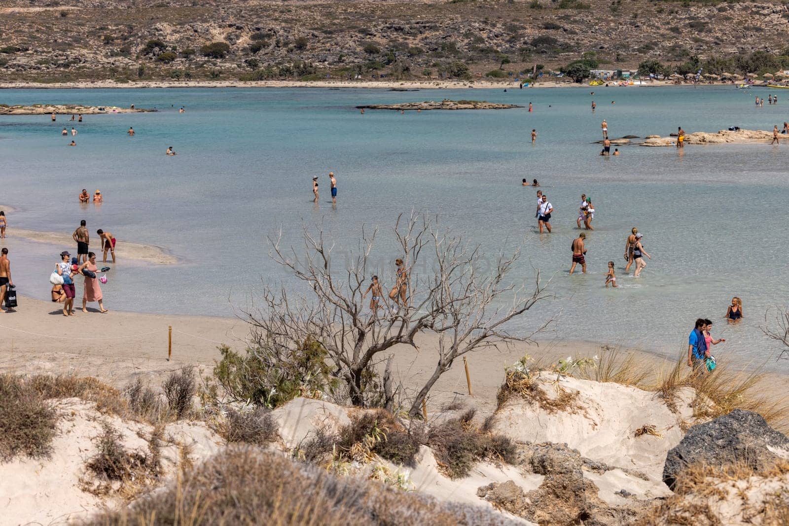 Elafonisi, Crete, Greece - Sept 19, 2021: People relaxing on the famous pink coral beach of Elafonisi on Crete, Mediterannean sea, Greece