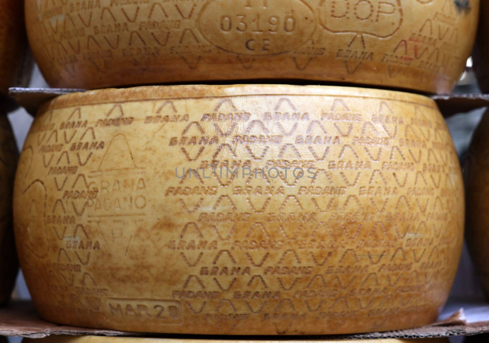 Cremona, Italy - September 7, 2022: Whole wheels of Parmigiano Reggiano cheese sold at a street stall during the farmers market in Cremona, Lombardy, Italy