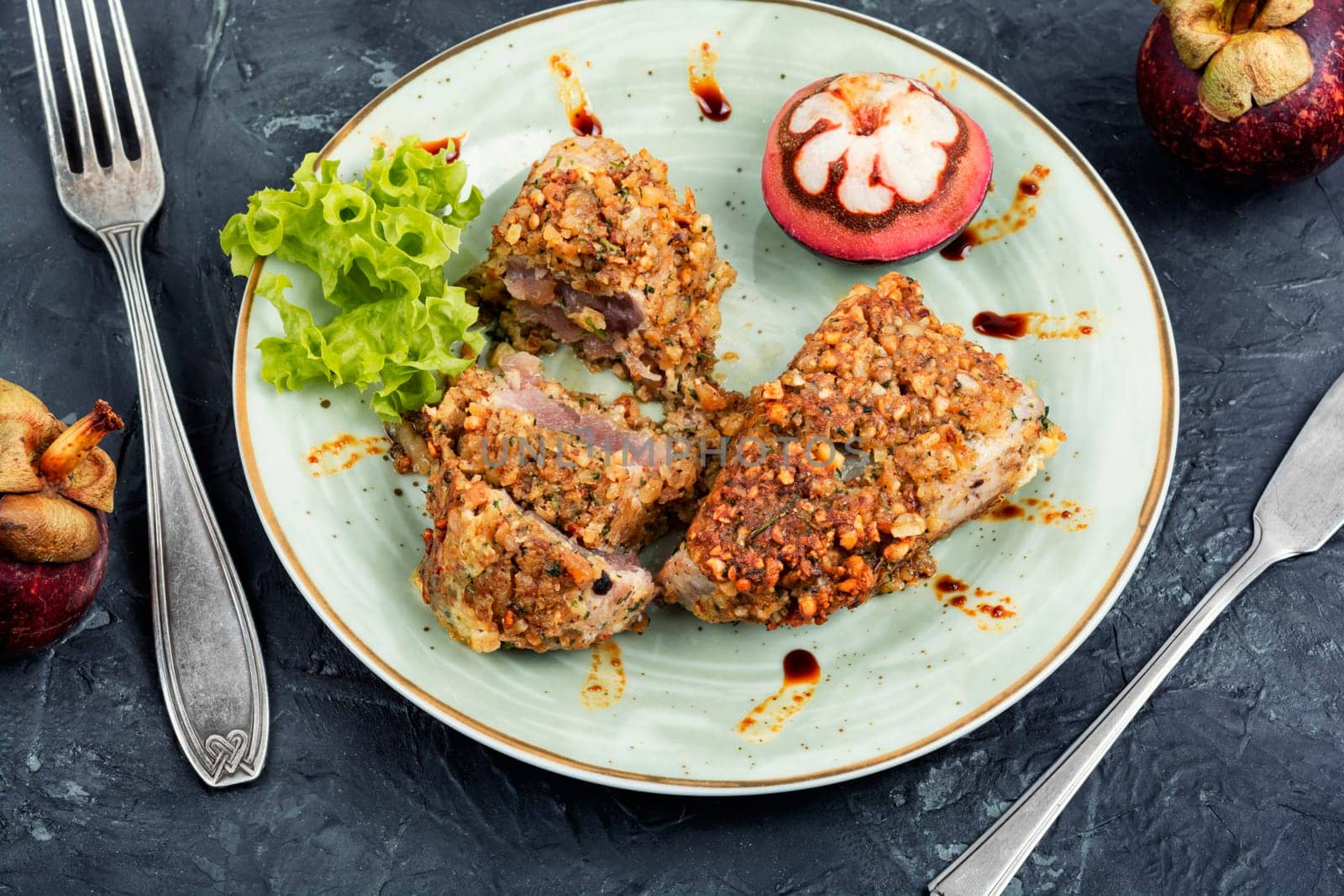 Plate of steak of baked tuna in a nut panic with a mangosteens.