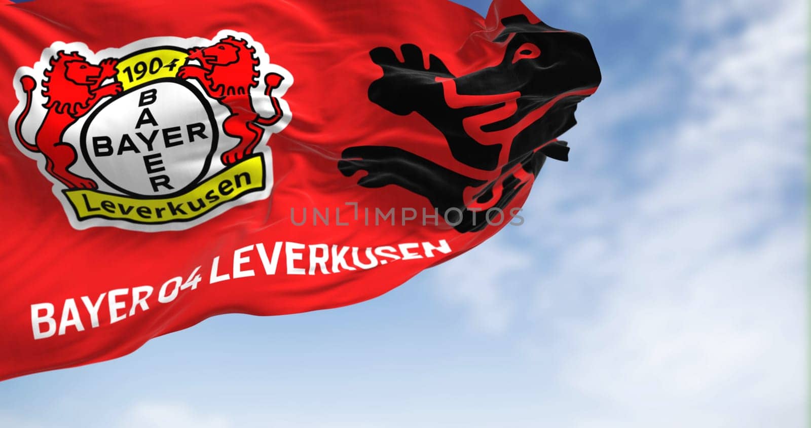 Leverkusen, DE, Aug 2 2023: Bayer Leverkusen flag waving in the wind on a clear day. illustrative editorial 3d illustration render. Fluttering fabric. German Bundesliga Football club
