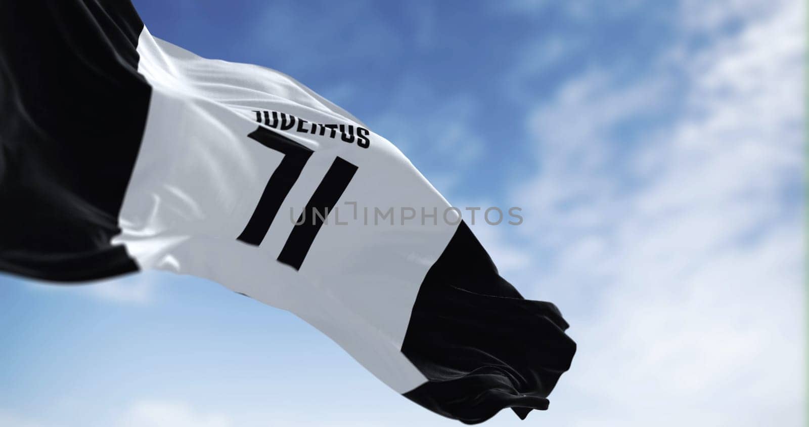 Turin, Italy, Aug 1 2023: Juventus Football Club flag waving on a clear day. Italian professional football club based in Turin. Illustrative editorial 3d illustration render. Selective focus