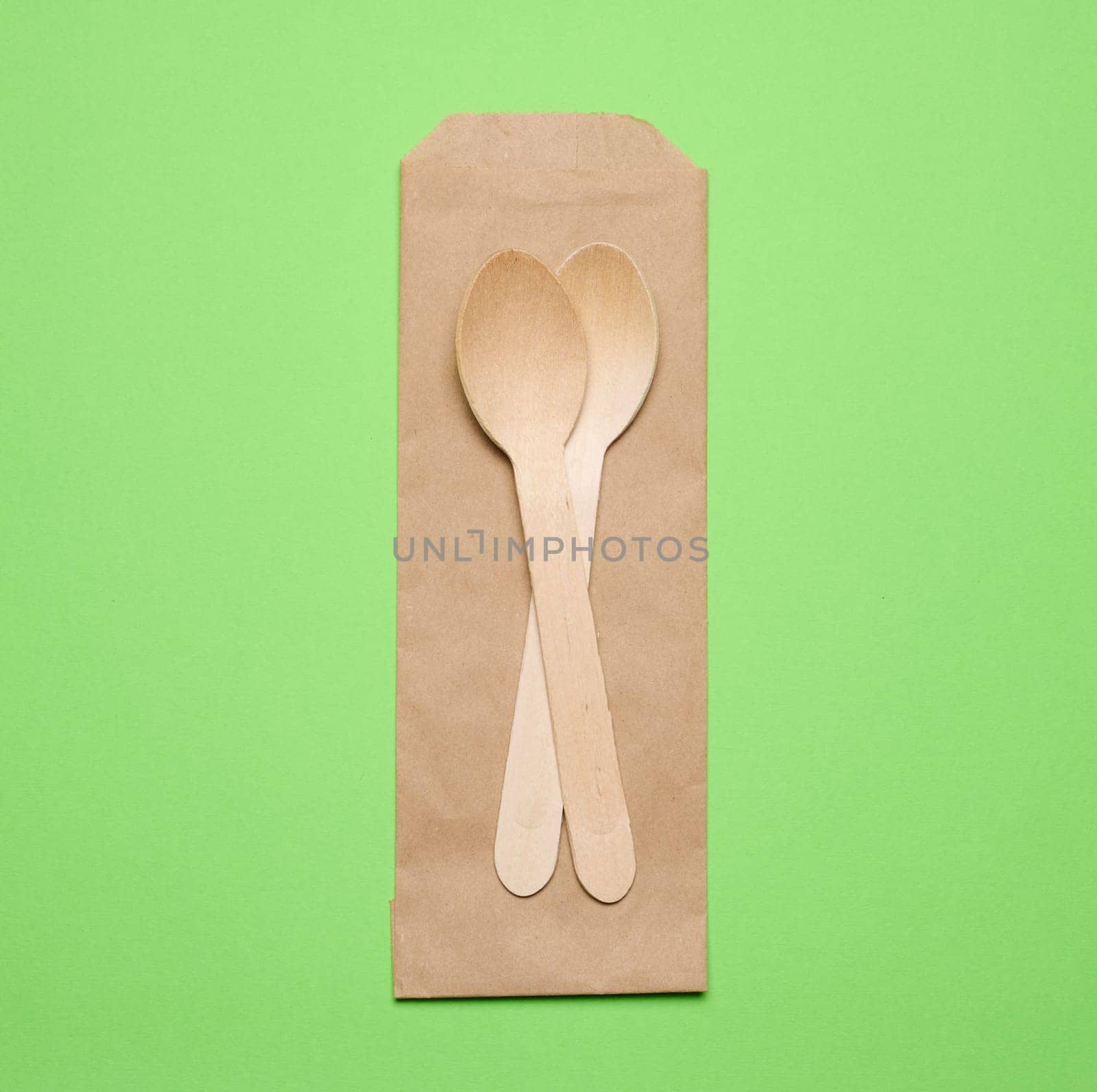 Wooden spoons on a green background, top view