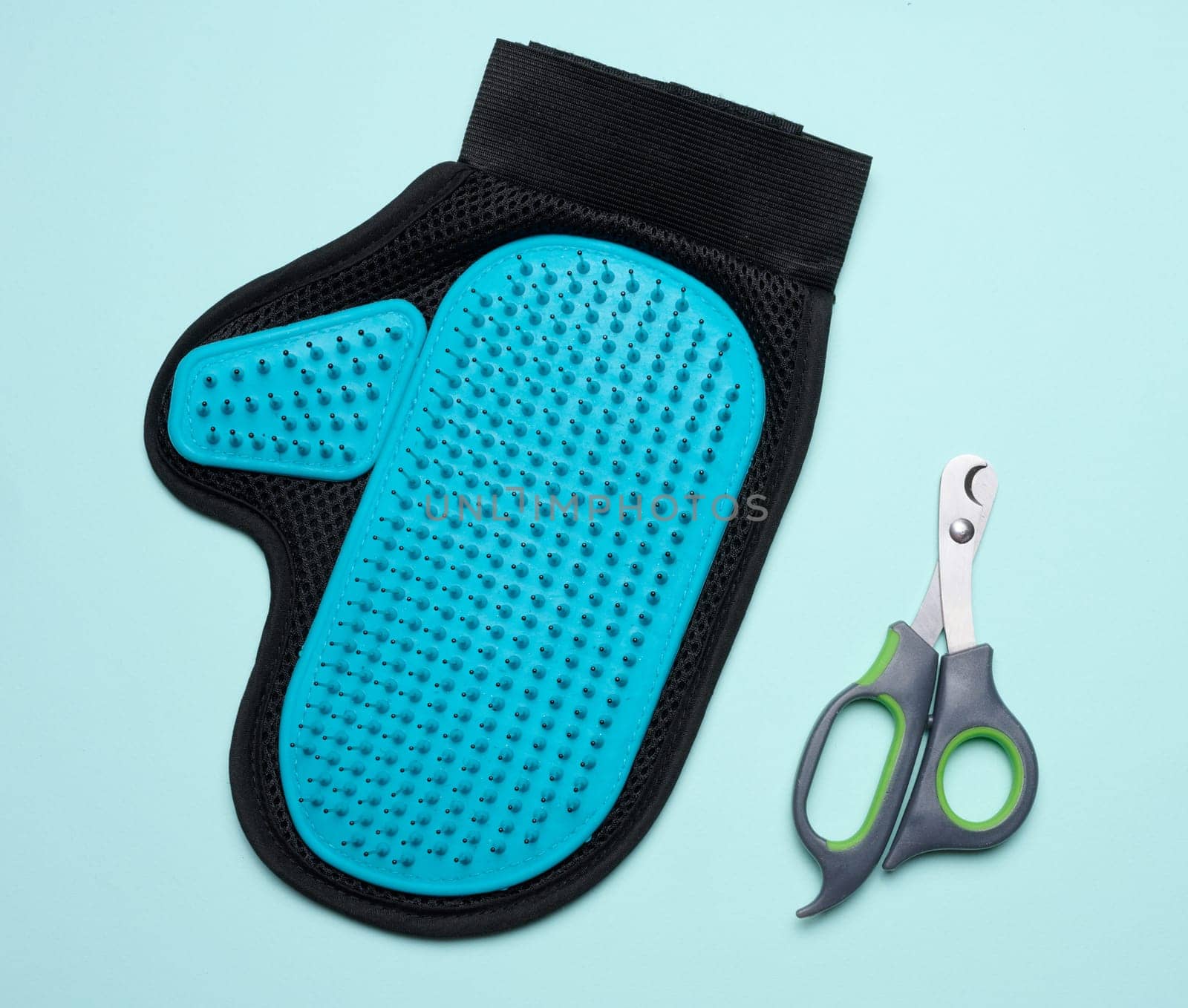 Animal nail scissors and a serrated glove for combing hair, top view