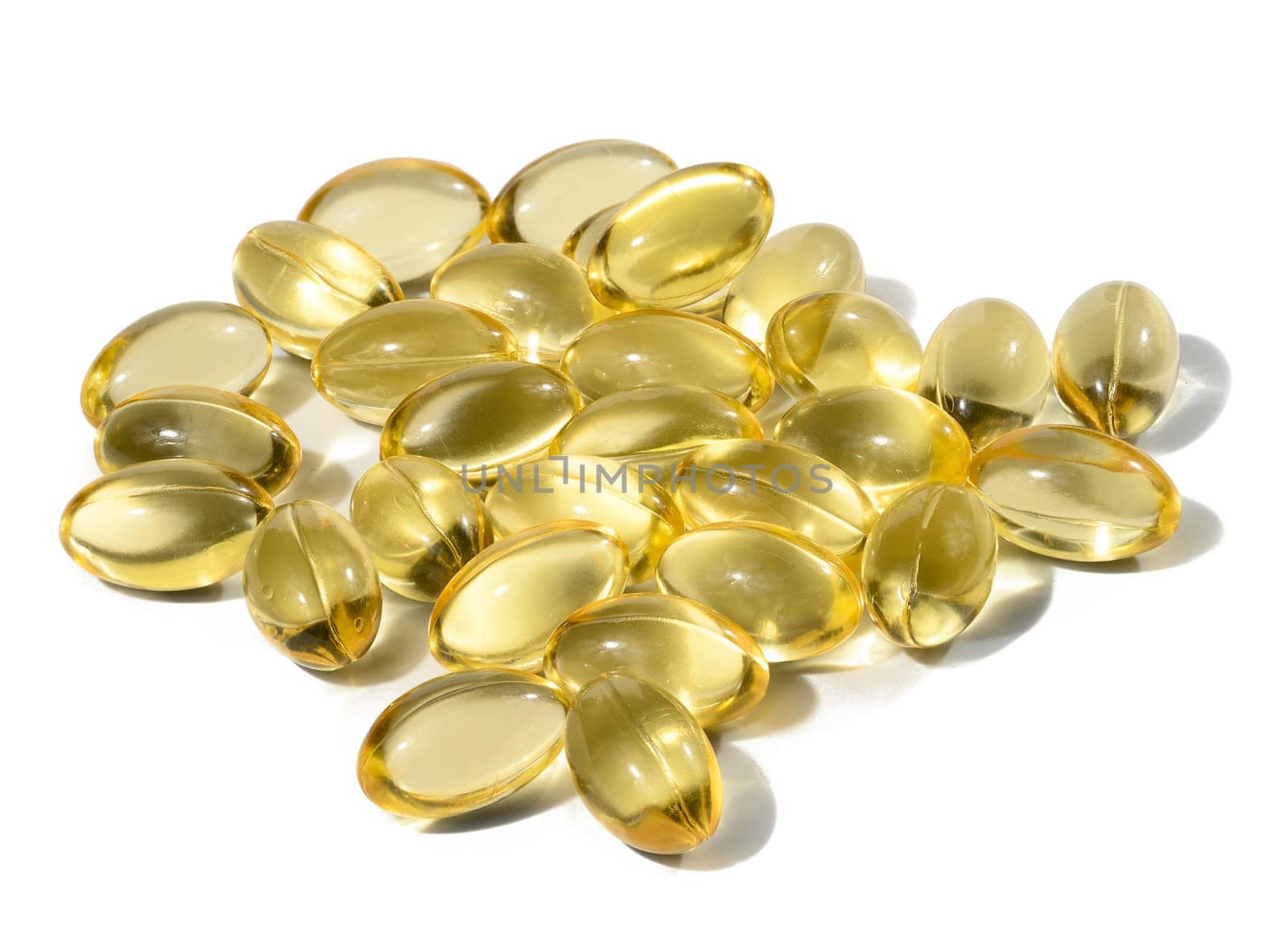 Yellow capsules with fish oil on a white background, close up