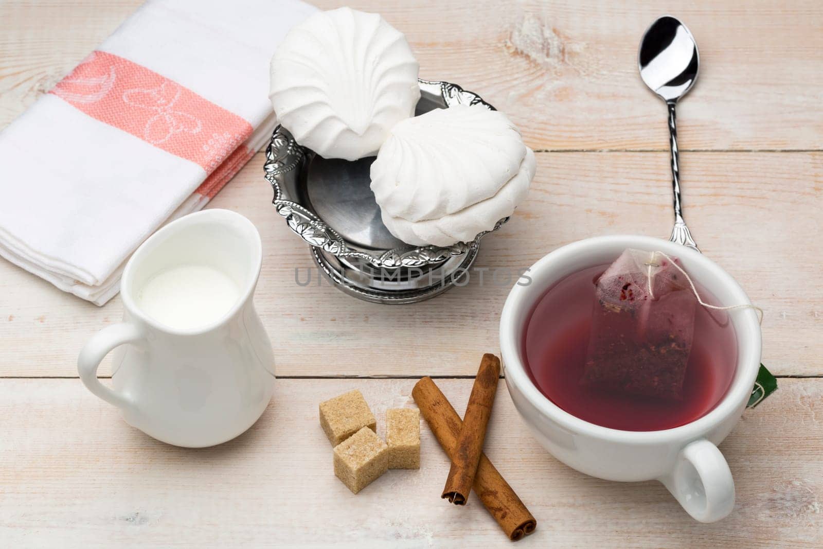 Set of cup red tea and dessert on bright wooden table