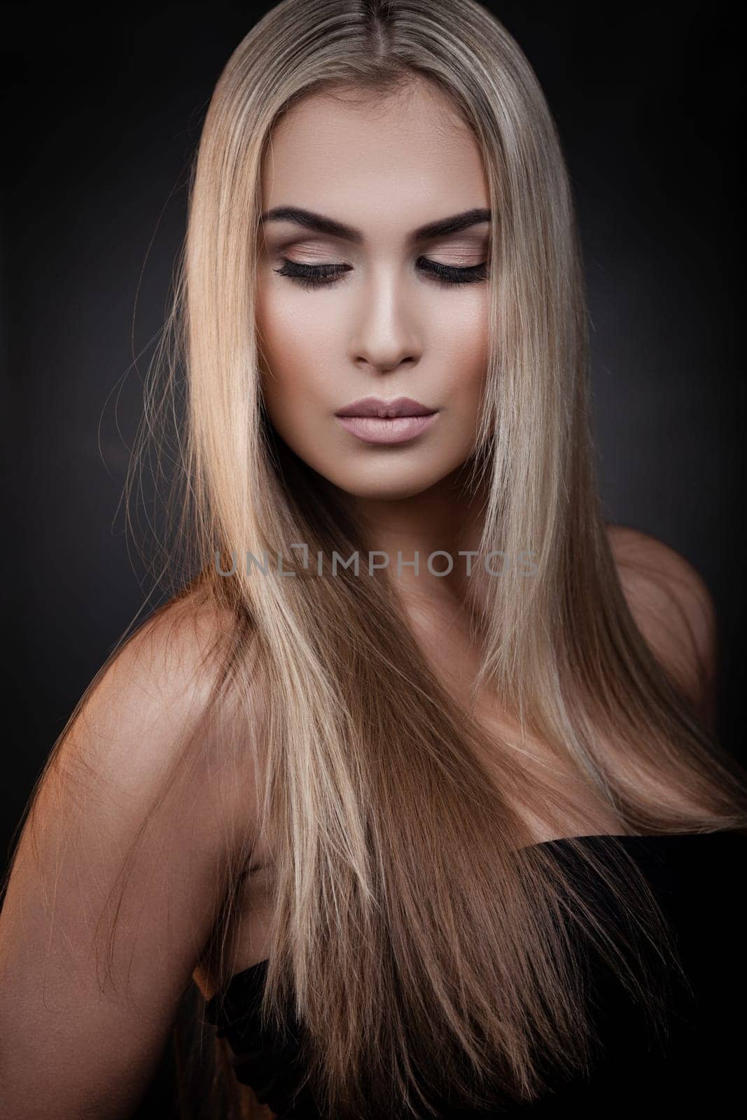 Sexy blond woman posing on dark background