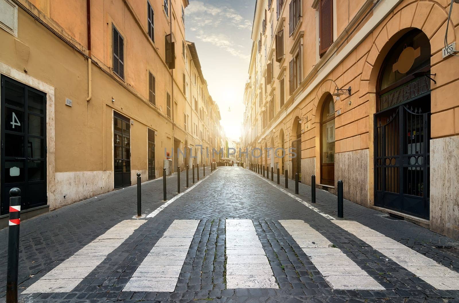 Sunrise over street with pedestrian crossing in Rome