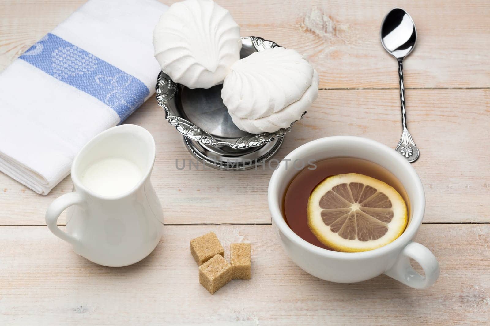 Set of white cup of black tea with slice lemon and sweet dessert