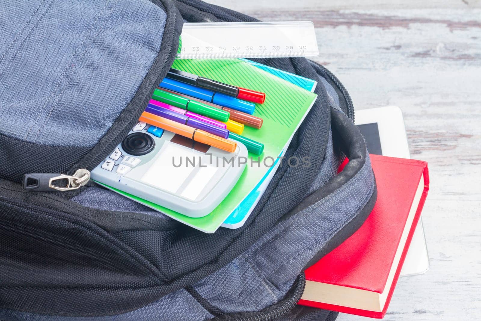 Open school backpack with supplies close up