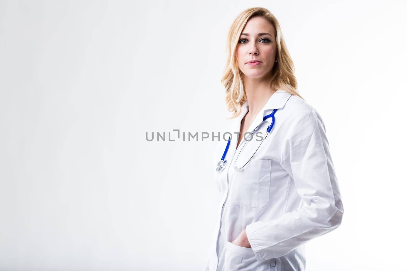 this beautiful blonde woman on a white coat is a doctor and she's waiting for her patient to tell her what's the problem because she's wellcoming