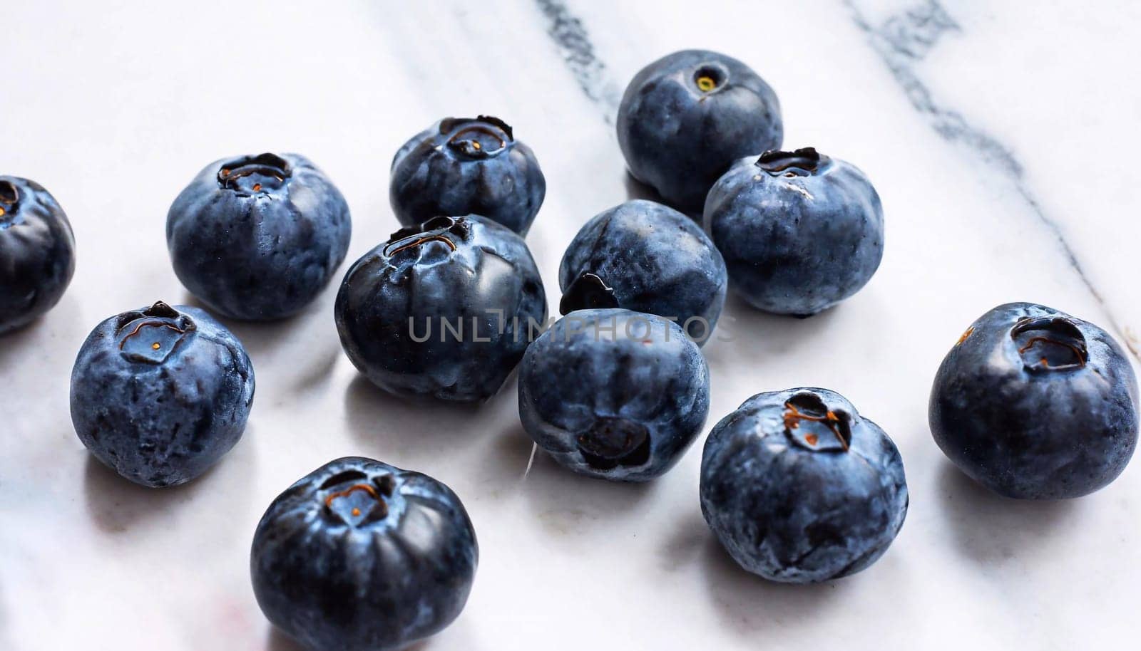 Juniper berries on and beside black bowl. Fresh juniper berries and branches.