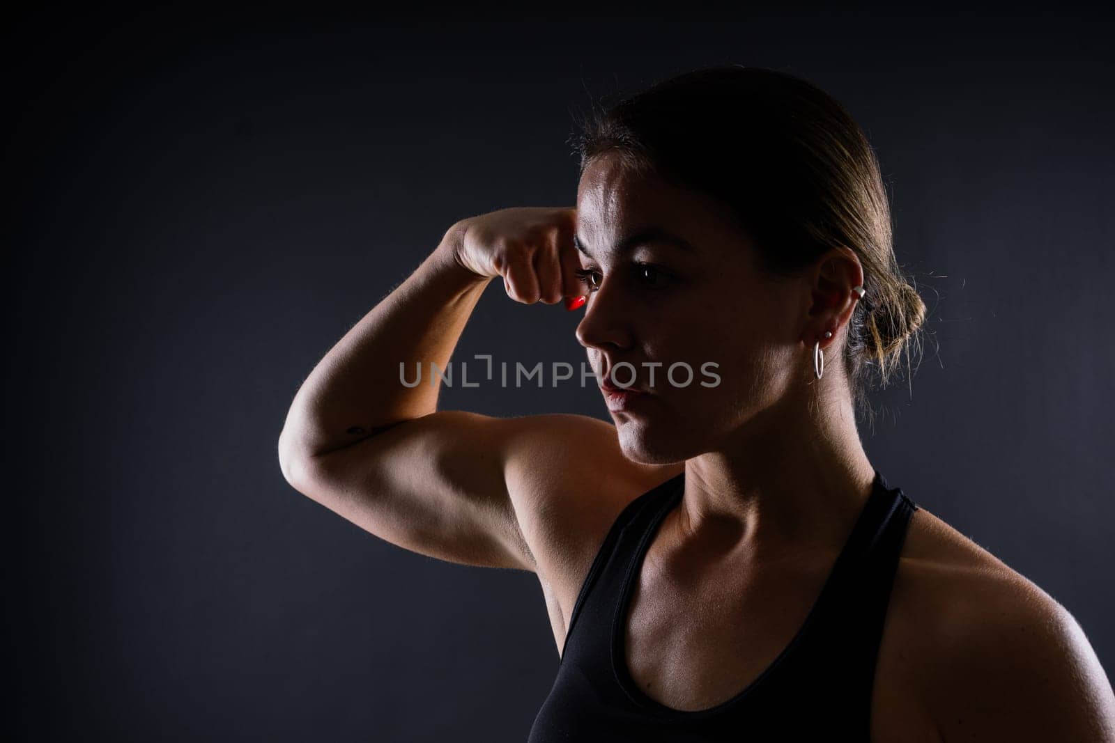 Portrait of female mixed martial arts fighter with a bandage and gloves on her hands.