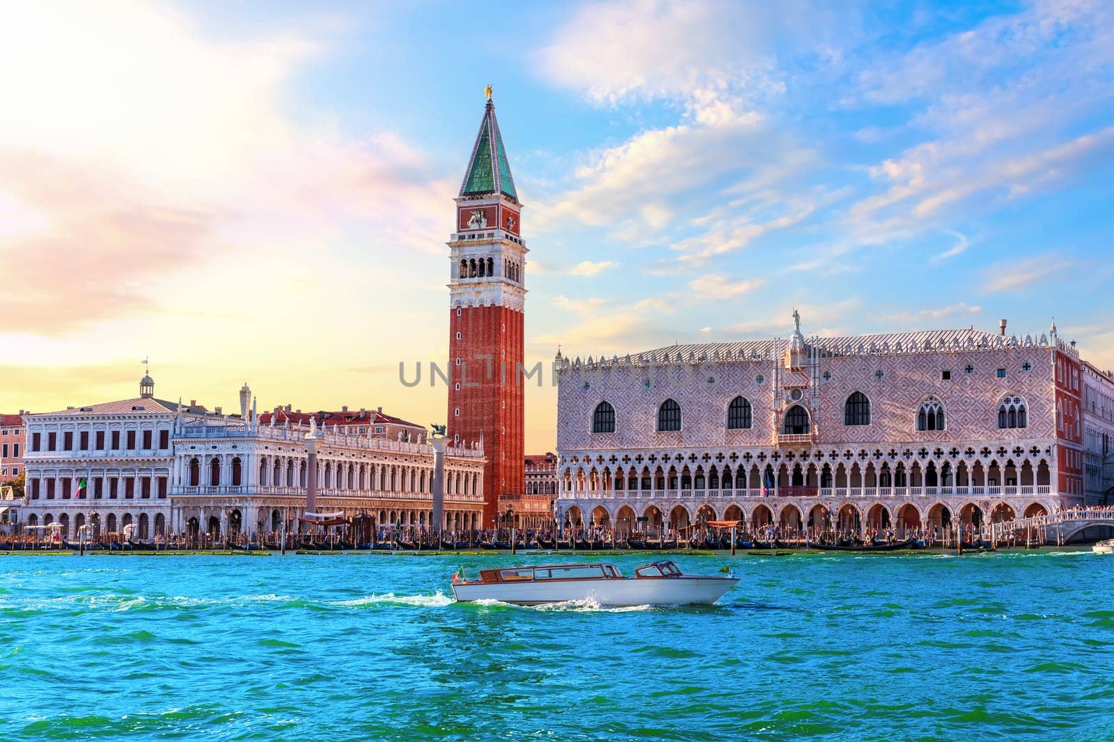 San Marco and Doge's Palace of Venice with many tourists under a sunset sky, Italy.