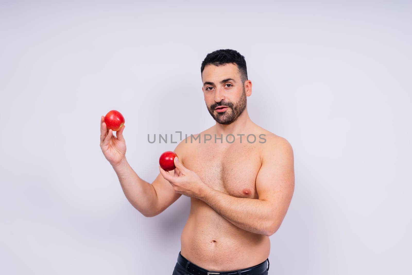 Full isolated studio picture from a young naked man with underwear and tomatoes