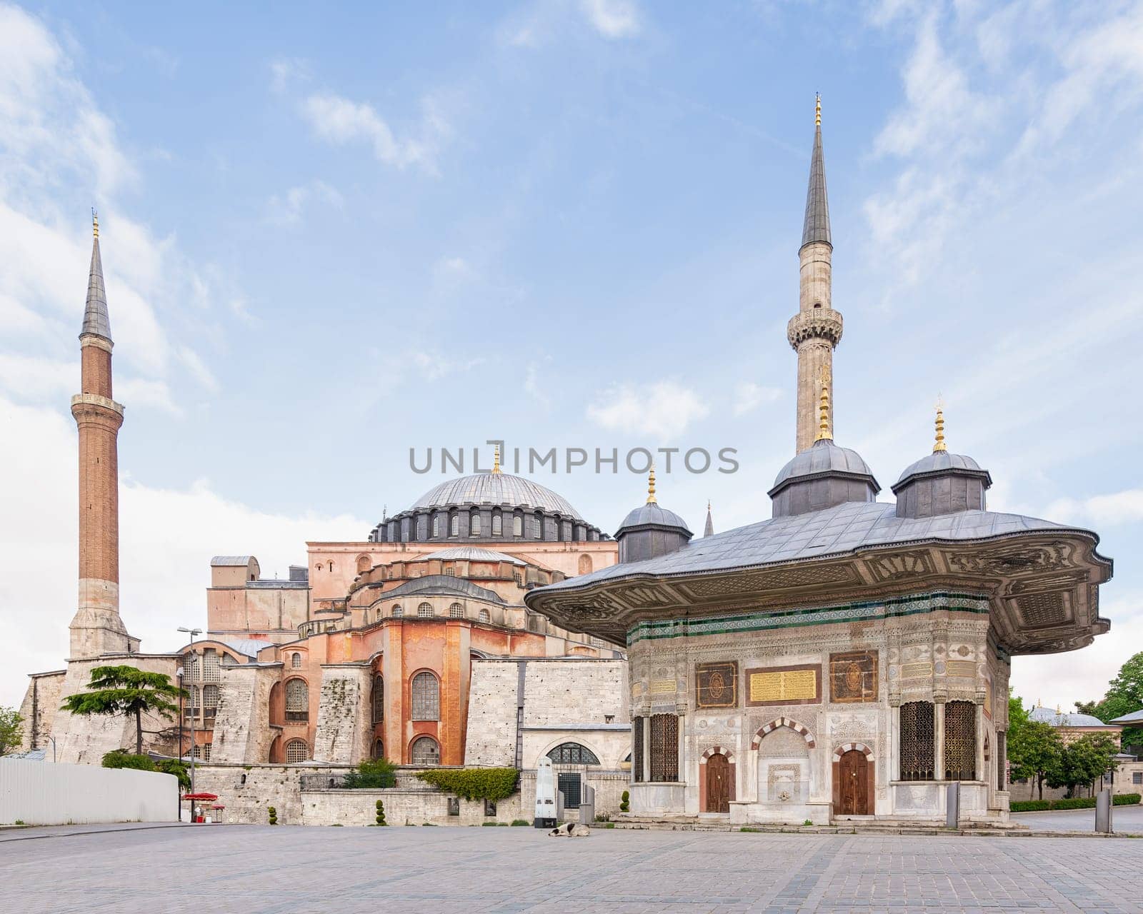 17th century Turkish rococo water fountain of Sultan Ahmed III, or Ahmet Cesmesi, with Hagia Sophia in the far end, in the Great Square, near the Imperial Gate of Topkapi Palace, Istanbul, Turkey