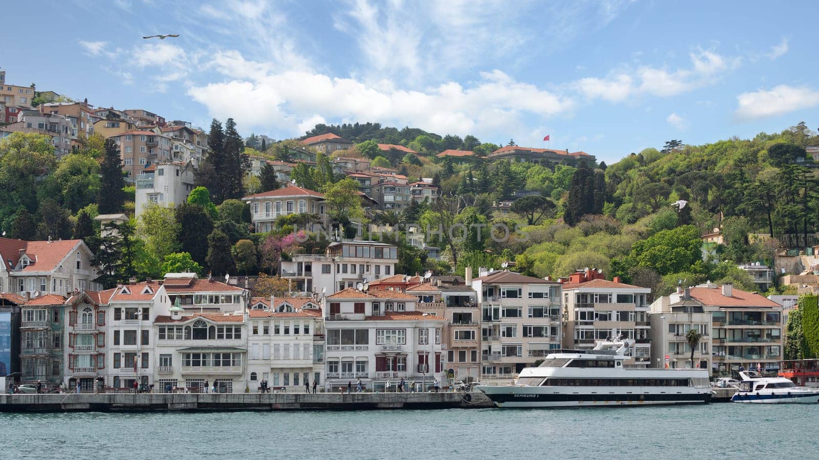 Istanbul, Turkey - May 8, 2023: View from Bosphorus Strait of traditional houses of Arnavutkoy district, in midday light, with the sun shining brightly and the sky a clear blue